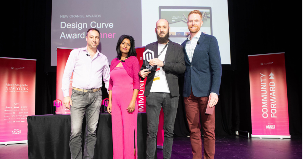 Meet Magento New York stage with backlit screen displaying the Hyvä Design Awards and a single white podium below